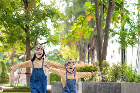 A cute little girl dressed in a cap and glasses of a pilot. The child dreams of becoming a pilot.の写真素材