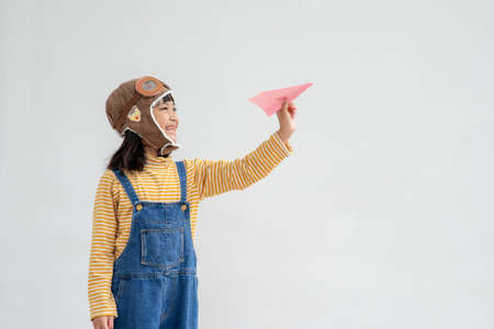 Happy Asian kid playing with a paper airplaneの写真素材