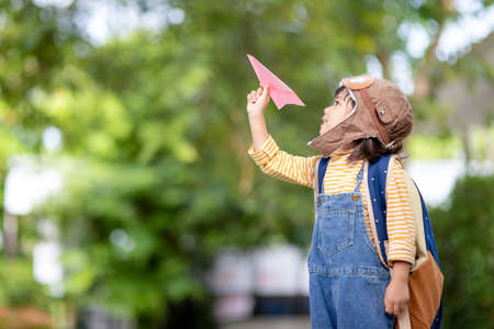 Happy Asian kid playing with a paper airplaneの写真素材