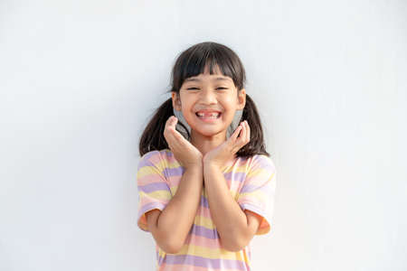 Portrait of surprised cute little toddler girl child standing isolated over white background. looking at the camera. hands near open mouthの写真素材