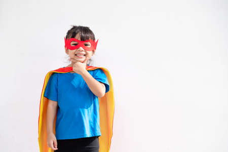 Kids concept, smiling girl playing super hero on white backgroundの写真素材
