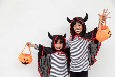 happy Halloween! two children in Halloween costumes and with pumpkins on white backgroundの写真素材