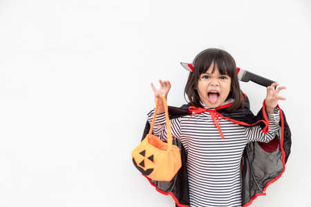 Funny Halloween Kid Concept, little cute girl with costume Halloween ghost scary he holding orange pumpkin ghost on hand, on white backgroundの写真素材