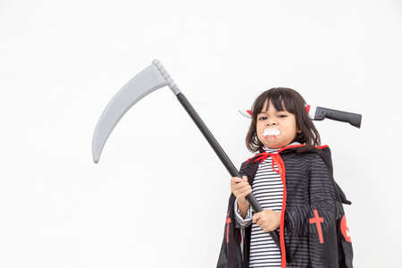 Children girl wearing mysterious Halloween dress holding a sickle on white background
