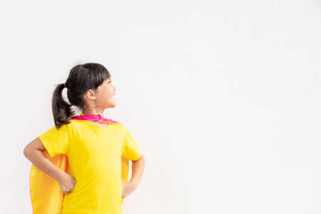 Funny little girl playing power superhero over white background. superhero concept.の写真素材