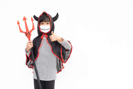 Asian little girl in a Halloween costume in a medical mask . Halloween with safety measures from...