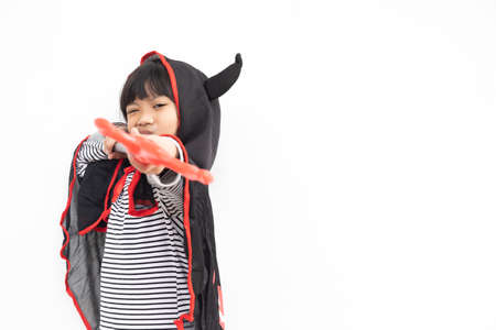 Asian child girl in demon costume holding black and red trident, happy halloween conceptの写真素材