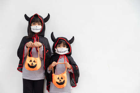 Happy sibling girls at the halloween party. children wearing costumes halloweens. concept of...