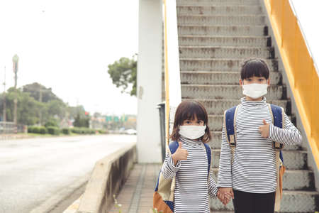 School child wearing a face mask during coronavirus and flu outbreak. Little girl going back to...