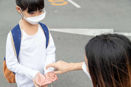 Family with kids in the face mask in a shopping mall. Mother and daughter wear facemask during coronavirus and flu outbreak. Virus and illness protection, hand sanitizer in a public crowded place.の写真素材