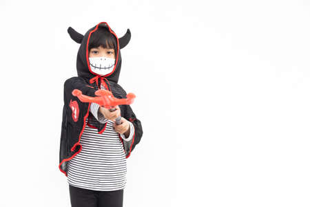 Asian little girl in a Halloween costume in a medical mask . Halloween with safety measures from Covid-19の写真素材