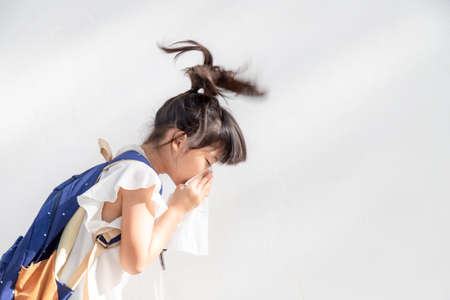 Asian child girl sick with sneezing on the nose and cold cough on tissue paper because weak or virus and bacteria from dust weatherの写真素材