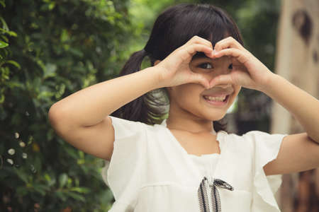 Little girl hands making a heart shape on white backgroundの写真素材
