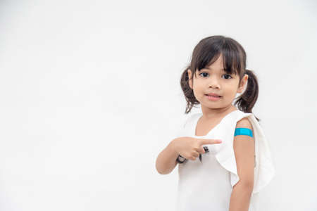 Asian little girl showing his arm after got vaccinated or inoculation, child immunization, covid delta vaccine conceptの写真素材