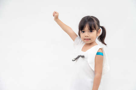 Asian little girl showing his arm after got vaccinated or inoculation, child immunization, covid delta vaccine conceptの写真素材