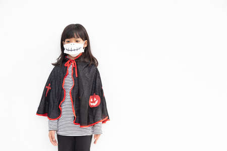 Asian little girl in a Halloween costume in a medical mask . Halloween with safety measures