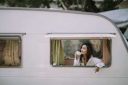 morning, coziness, winter and people concept - close up of happy young woman with cup of coffee or...