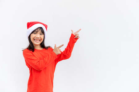Asian little girl in red Santa hat on white background.の写真素材