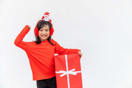 Happy Asian child in Santa red hat holding Christmas presents. Christmas time.on white background.の写真素材