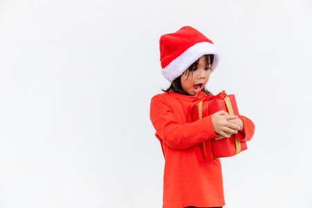 Happy Asian child in Santa red hat holding Christmas presents. Christmas time.on white background.の写真素材