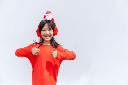 Asian little girl in red Santa hat on white background.の写真素材