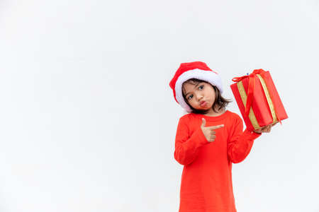Happy Asian child in Santa red hat holding Christmas presents. Christmas time.on white background.の写真素材