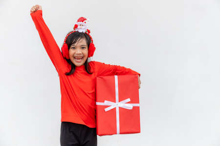 Happy Asian child in Santa red hat holding Christmas presents. Christmas time.on white background.の写真素材