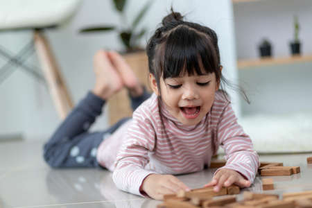 Asian sibling  girl playing wooden stacks at homeの写真素材