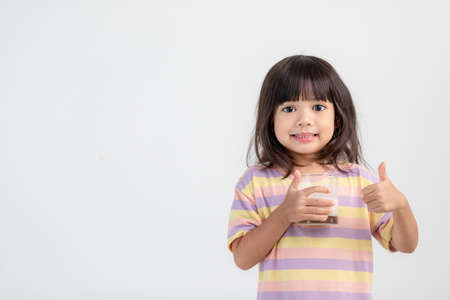 Smiling of Asian girl with a glass of milkの写真素材