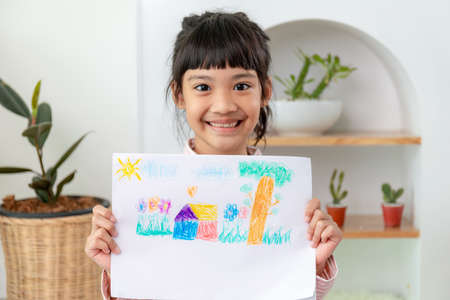 Little preschool girl displaying her picture proudlyの写真素材