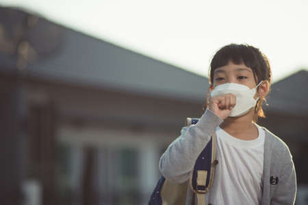 Asian child girl wearing mask sick with sneezing on the nose and cold coughの写真素材