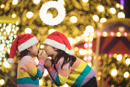 Merry Christmas happy children with a magic gift at home near Christmas treeの写真素材