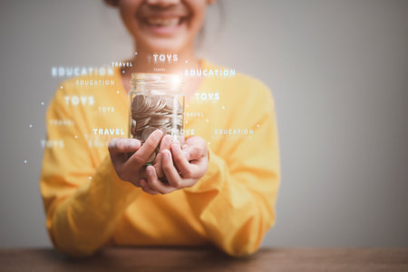 Cute Asian little child girl making stacks of coins . Kid saves money for future education. Money, finances, and people conceptの写真素材