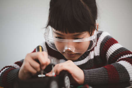 Inventive kid constructing robot cars at homeの写真素材