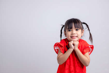 happy Chinese new year. Little Asian girls with Congratulation gestureの写真素材