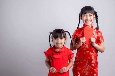 happy Chinese new year. smiling Asian little girls holding red envelopeの写真素材