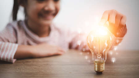 Child with a bright light bulb. Concept of Ideas for presenting new ideas Great inspiration and innovation new beginning.の写真素材