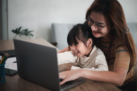 Mother working at home-office with daughter on her lapの写真素材