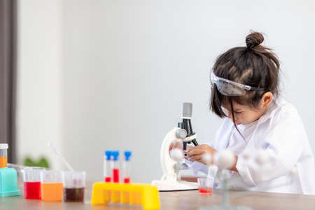 education, science, chemistry and children concept - kids or students with test tube making experiment at school laboratoryの写真素材