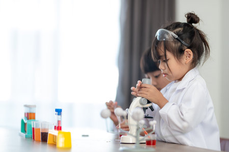 education, science, chemistry and children concept - kids or students with test tube making...