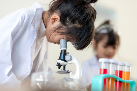 education, science, chemistry and children concept - kids or students with test tube making experiment at school laboratoryの写真素材