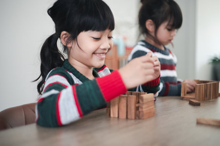 Cheerful Asian girl playing with wooden building blocks. Having fun and learning creativity. smart kid concept.の写真素材