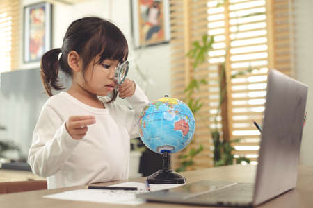 Asian girl student online learning class study online video call zoom teacher, Happy girl learn english language online with laptop at home.の写真素材