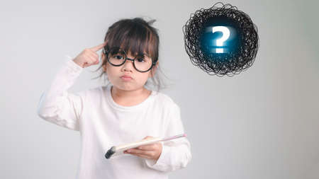 asian little girl thinking with question markの写真素材