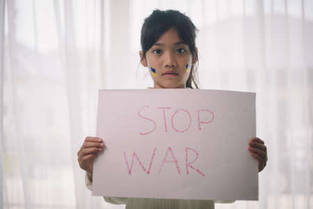 Board No war, Stop war. Little Asian girl. No war with Ukraine. Ukrainian geopolitics globe crisis.