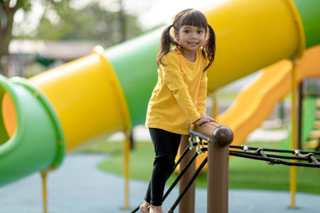 Asian little girl enjoys playing in a children playground, Outdoor portrait
