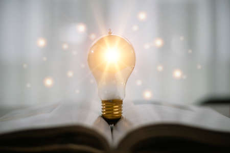 light bulb glowing on book, idea of ââinspiration from reading, innovation idea concept, Self learning or education knowledge and business studying concept.の写真素材