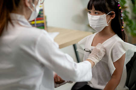 Doctor examining a little girl by stethoscopeの写真素材