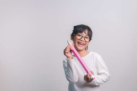 Excited young girl kid holding up big pencils in her hands.Back to school.