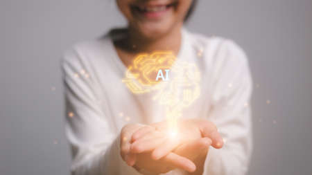 AI technology concept on virtual screen.girl hands holding the brain innovative technology in science and communication conceptの写真素材